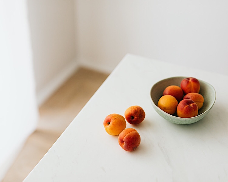 weisser Tisch mit einer Schale Aprikosen