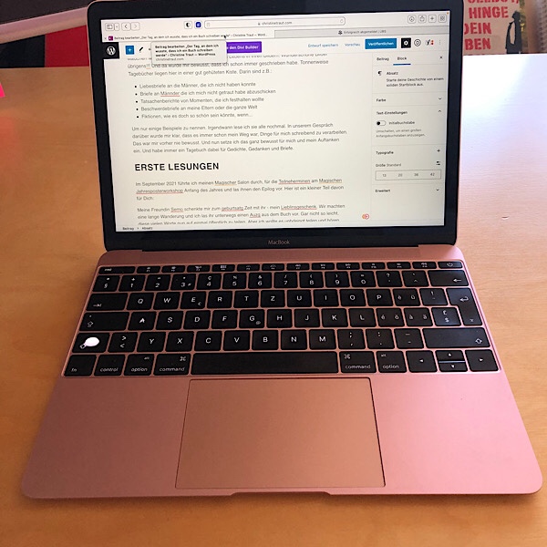 Rosegoldener Laptop mit Text auf dem Bildschirm 