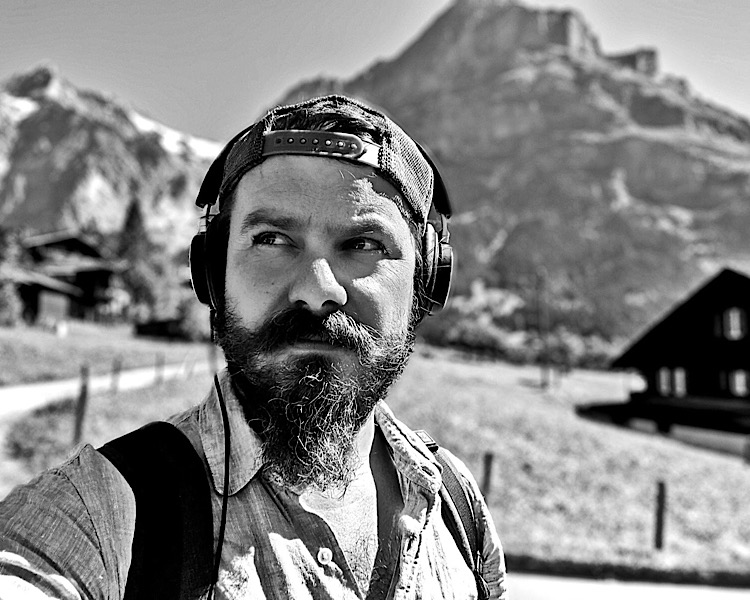 Florian mit Rucksack vor einem Berg in Schwarz-weiss