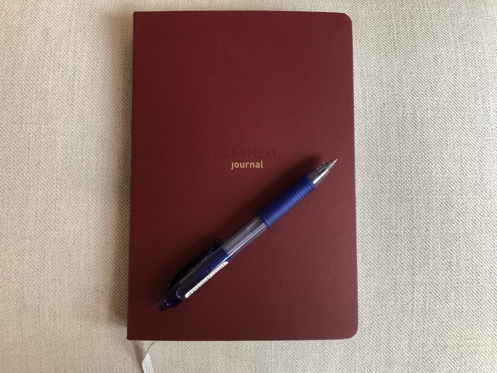 rotes Journal "Klarheit" mit Stift